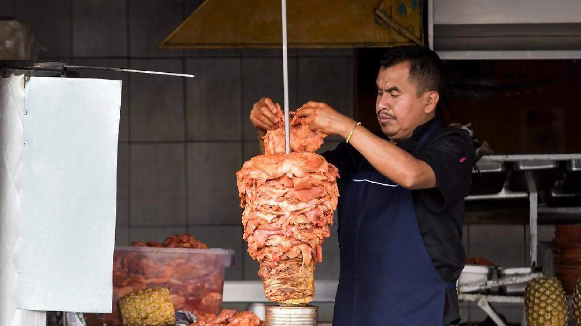 Taquero preparando un trompo de pastor